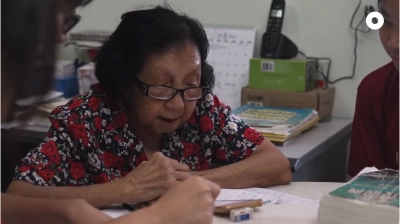 elderly chinese lady wearing glasses holding a smartphone