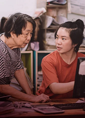 an elderly woman speaking with a younger woman