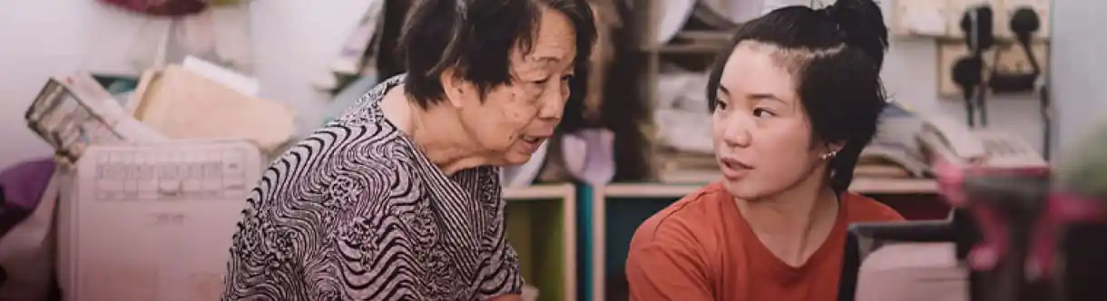 an elderly woman speaking with a younger woman