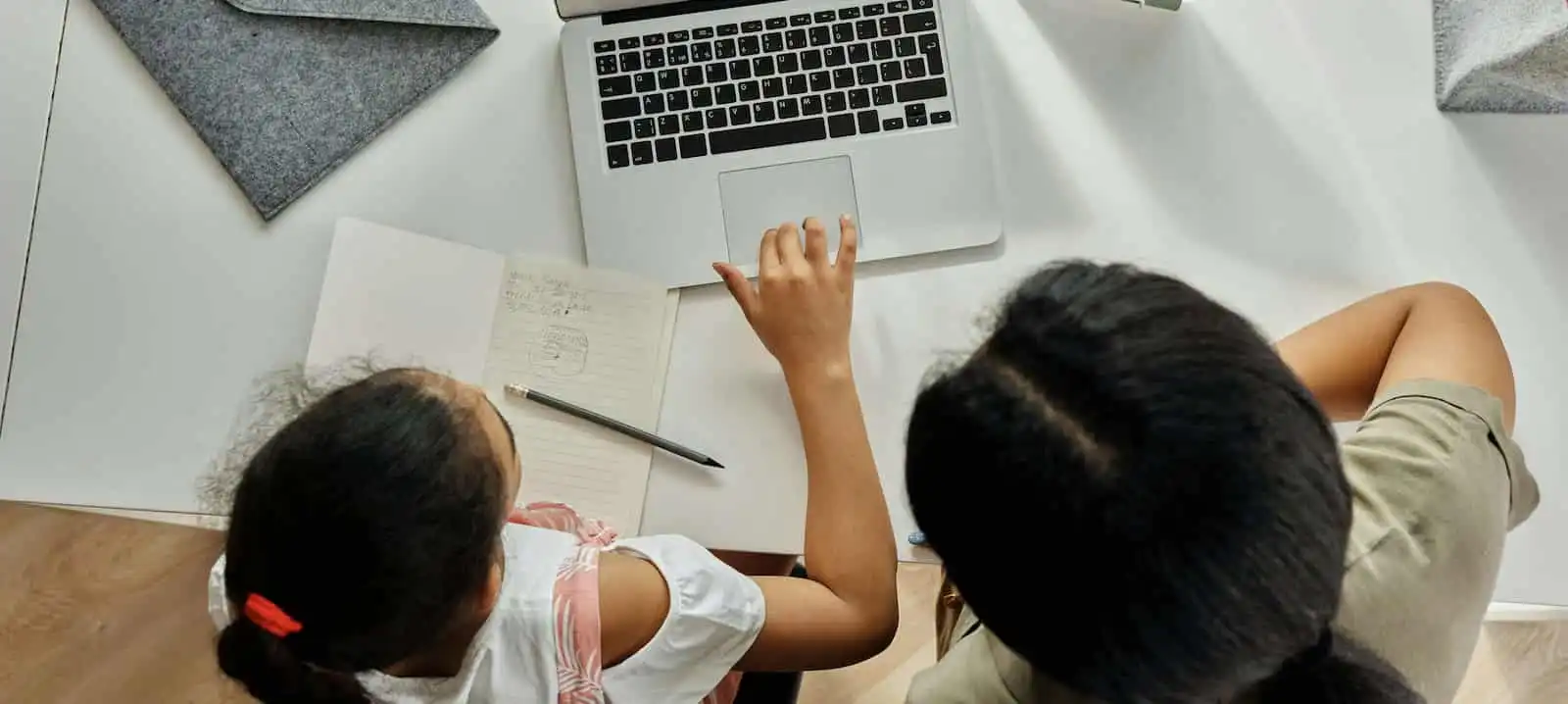 Teacher guiding a student on the computer.