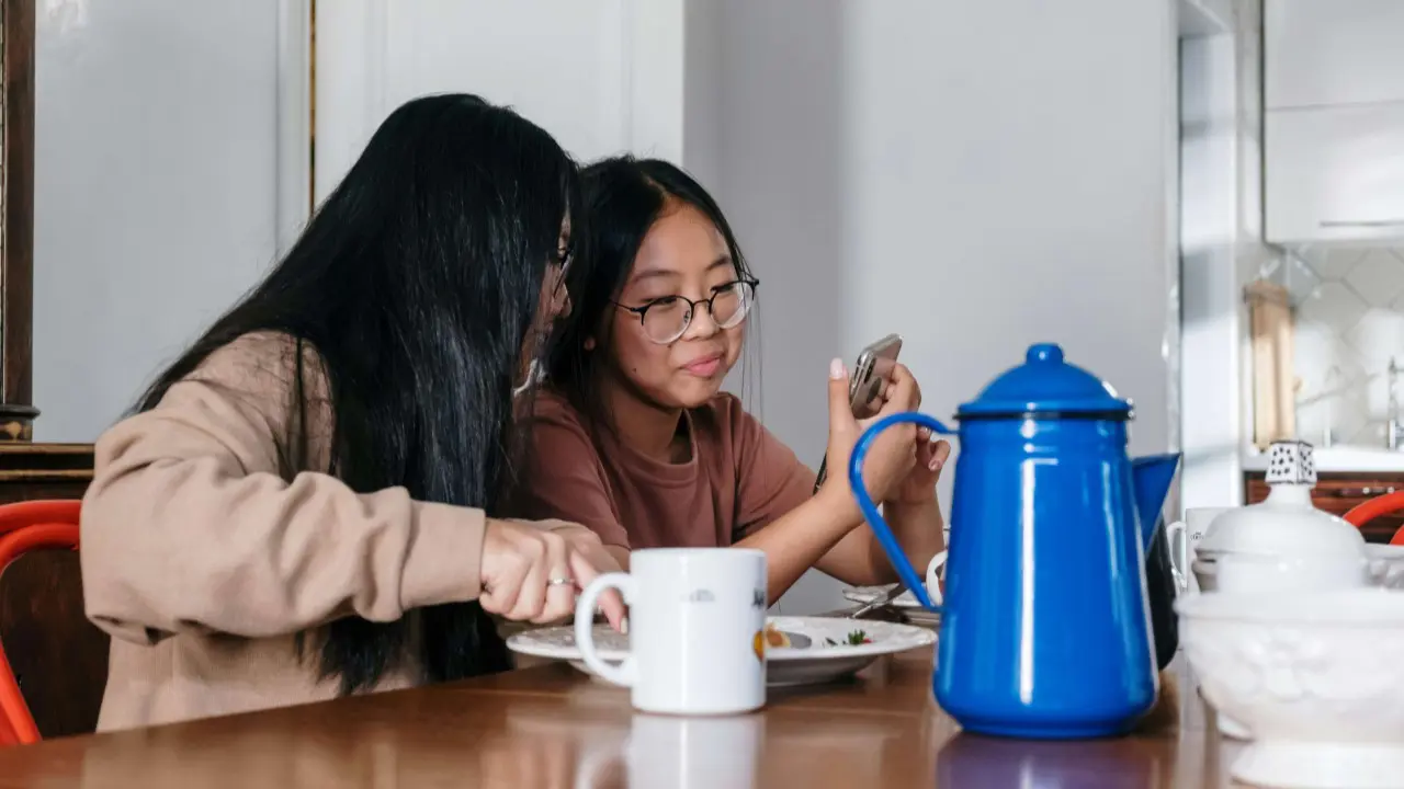 two-girls-looking-at-smartphone-content-casually-while-eating-desktop