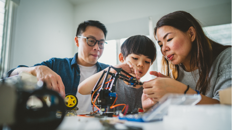 Parents guiding their child on a hands-on activity in robotics