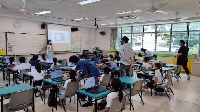 OSF Funded Project: Project D.I.P. team and students with laptops in a classroom under IMDA’s NEU PC Plus Programme