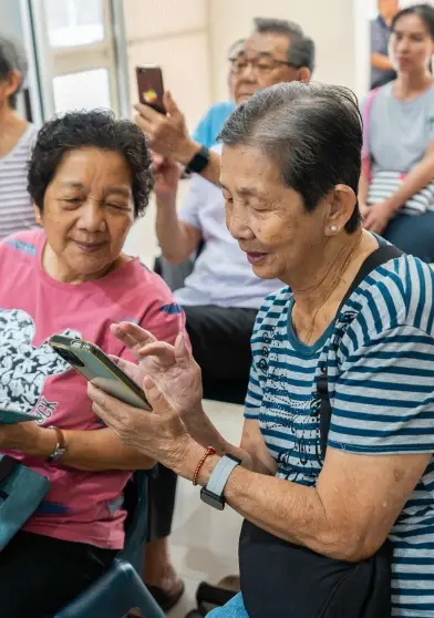 Two aunties using a handphone